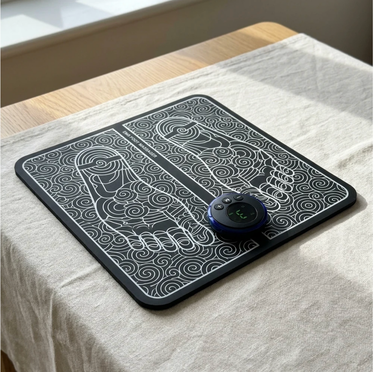 Tapis d'électrostimulation Naya Repose posé sur une nappe en lin